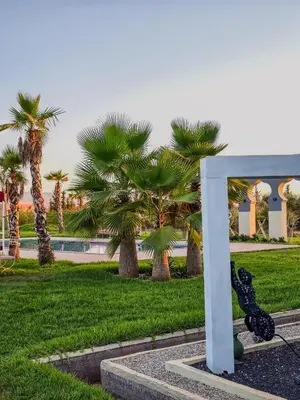a statue of a rabbit in a park with palm trees at Dar Muskana