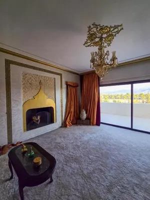 a living room with a fireplace and a chandelier at Dar Muskana