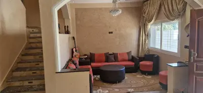 a living room with a red couch and a staircase at Villa in Meknès