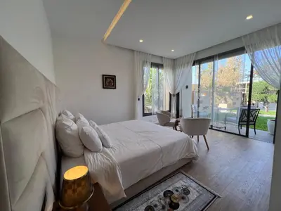 a bedroom with a white bed and a large window at Villa Fiori Luxury Italian Villa, Pool & Spa, Marrakech in Douar bel Rhanodour
