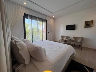a bedroom with a bed and a large window at Villa Fiori Luxury Italian Villa, Pool & Spa, Marrakech in Douar bel Rhanodour
