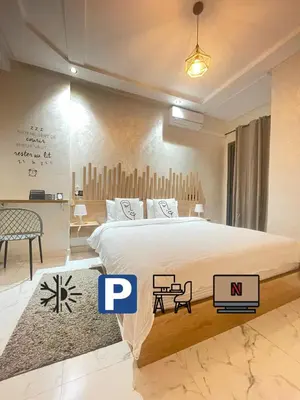 a bedroom with a large bed and a table at Lovely apartment city center in Meknès