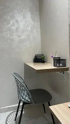 a chair sitting next to a shelf in a room at Lovely apartment city center in Meknès