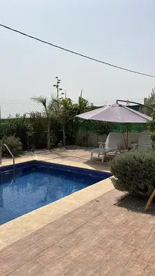 a swimming pool with a table and an umbrella at Villa 2 houses, pool, nature view