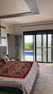 a bedroom with a large bed with a large window at Villa 2 houses, pool, nature view