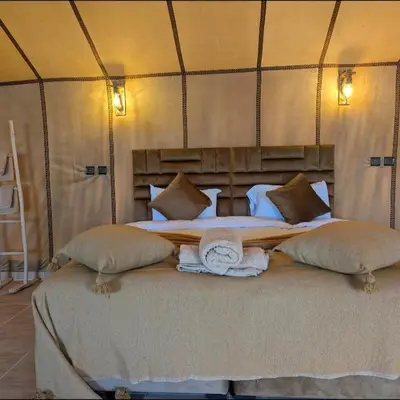 a bedroom with a large bed in a tent at Nomad Spirit Camp in Merzouga