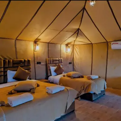 a bedroom with two beds in a tent at Nomad Spirit Camp in Merzouga