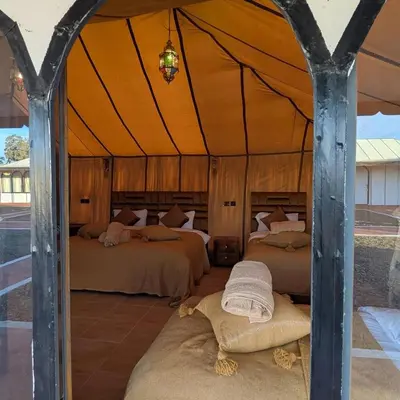 a bedroom with two beds in a tent at Nomad Spirit Camp in Merzouga