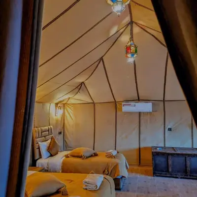 a room with two beds in a tent at Nomad Spirit Camp in Merzouga