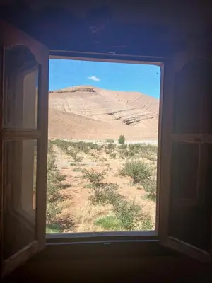 an open window looking out at a desert view at Auberge Ighounba in Tinerhir