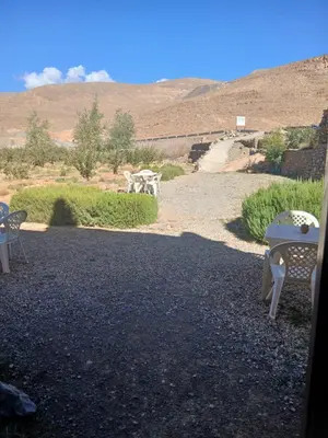 a group of chairs sitting on a gravel road at Auberge Ighounba in Tinerhir