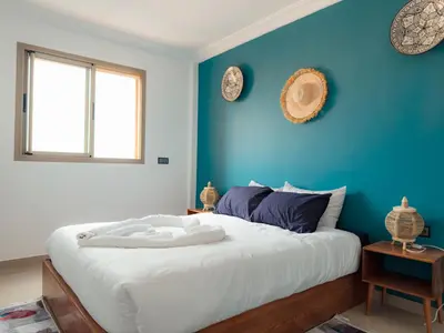 a bedroom with blue walls and a large bed at Fib Houses in Ouarzazate