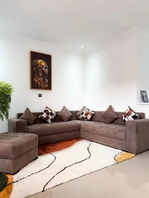 a living room with a brown couch and a rug at Fib Houses in Ouarzazate