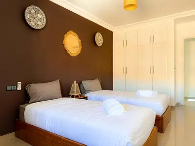 two beds in a room with clocks on the wall at Fib Houses in Ouarzazate