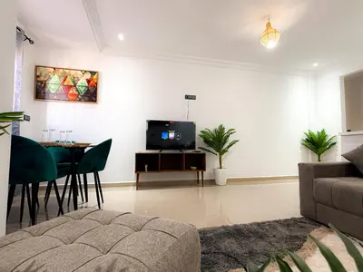 a living room with a couch and a table with a tv at Fib Houses in Ouarzazate