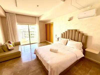 a bedroom with a large white bed and a couch at Reda's Apparts centre ville wifi 200 Mo in Fès