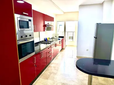 a kitchen with red cabinets and a stainless steel refrigerator at Reda's Apparts centre ville wifi 200 Mo in Fès