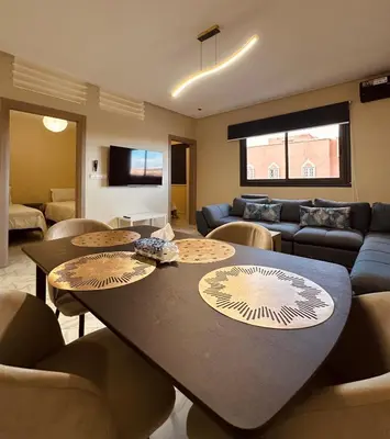 a living room with a table and chairs and a couch at Relax Family ApartHotel - Signature Residence in Ouarzazate