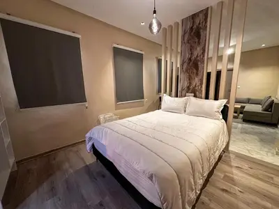 a bedroom with a large bed and a couch at Relax Family ApartHotel - Signature Residence in Ouarzazate