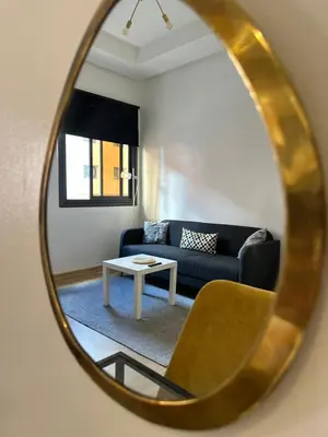 a mirror reflecting a living room with a blue couch at Relax Family ApartHotel - Signature Residence in Ouarzazate
