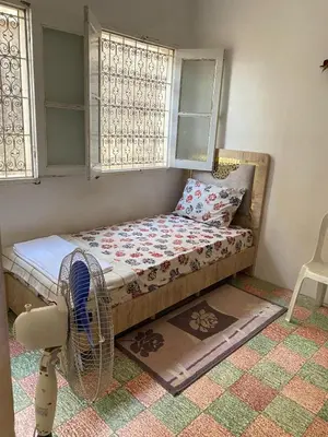 a small bedroom with a bed and a fan at Bedroom in medina in Fès