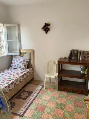 a bedroom with a bed and a desk and a table at Bedroom in medina in Fès