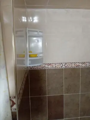 a small refrigerator in a bathroom with a tile wall at Bedroom in medina in Fès