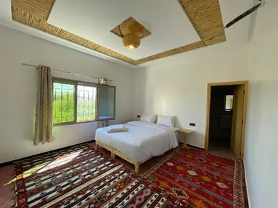 a bedroom with a bed and a rug at dar olivegarden inn in Ait Sedrate Sahl Gharbia