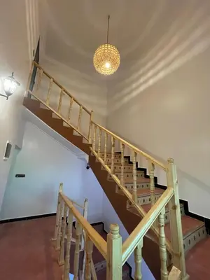 a wooden staircase in a room with a light fixture at dar olivegarden inn in Ait Sedrate Sahl Gharbia