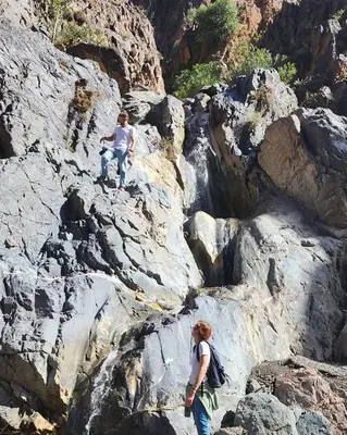 two people are standing on a rocky mountain at Gite ditabe tafoukte