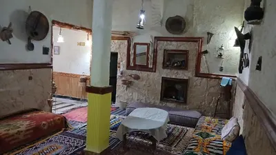 a room with a couch and a table and a fireplace at Gite ditabe tafoukte