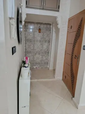 a bathroom with a shower with a tile wall at Dar ARAHA in Fès