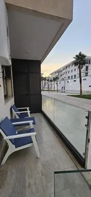 a balcony with lounge chairs and a swimming pool at Agadir bay in Oulad Akkou