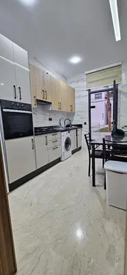 a kitchen with white appliances and a table in it at Agadir bay in Oulad Akkou