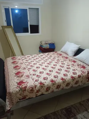 a bed with a red and white blanket on it at Appart hôtel tanger in Oulad Akkou