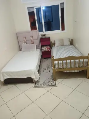 two beds sitting next to each other in a room at Appart hôtel tanger in Oulad Akkou