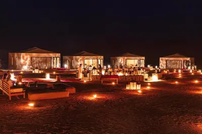 a group of tents with lights in the night at sahara bliss camp in Merzouga