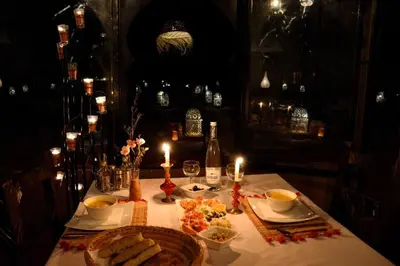 a table with a plate of food and a bottle of wine at sahara bliss camp in Merzouga