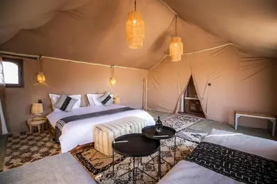 a bedroom with two beds in a tent at sahara bliss camp in Merzouga