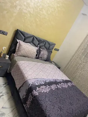 a bedroom with a bed with purple sheets and pillows at Al bassatine in Meknès
