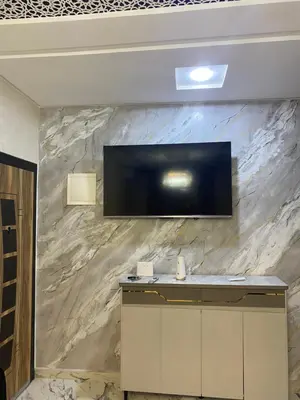 a flat screen tv on a stone wall at Al bassatine in Meknès