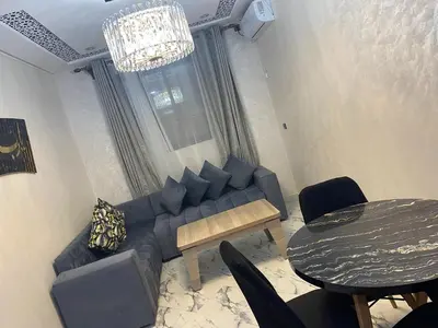 a living room with a couch and a table at Al bassatine in Meknès