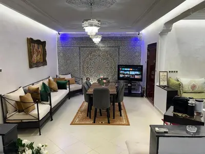 a living room with a table and a couch at Appartement Jardin Prestige - Fes Centre Ville in Fès