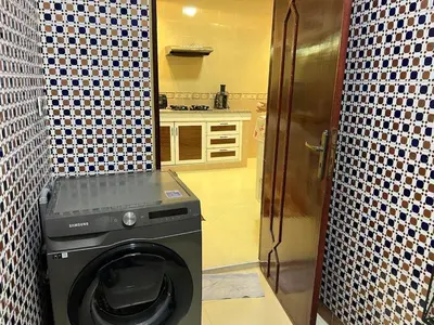 a washer and dryer in a bathroom with a kitchen at Appartement Jardin Prestige - Fes Centre Ville in Fès