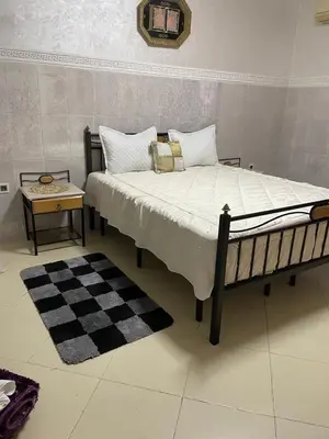 a bedroom with a large bed with a checkered floor at Appartement Jardin Prestige - Fes Centre Ville in Fès