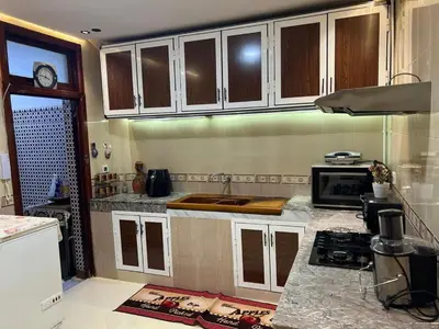 a kitchen with white cabinets and a counter top at Appartement Jardin Prestige - Fes Centre Ville in Fès