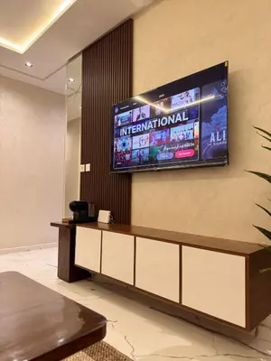 a television on the wall of a hotel lobby at Cozy Apartment 5 min From The City Center in Fès