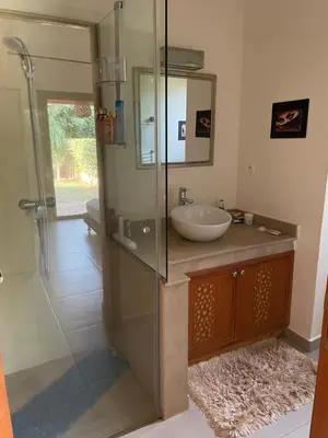 a bathroom with a sink and a glass shower at Olead in Aghmat
