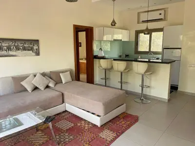 a living room with a couch and a kitchen at Olead in Aghmat