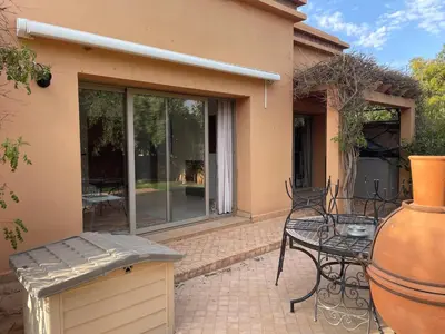 a patio with a table and a vase on a patio at Olead in Aghmat